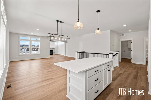 kitchen with visible vents, light wood-style floors, and white cabinets