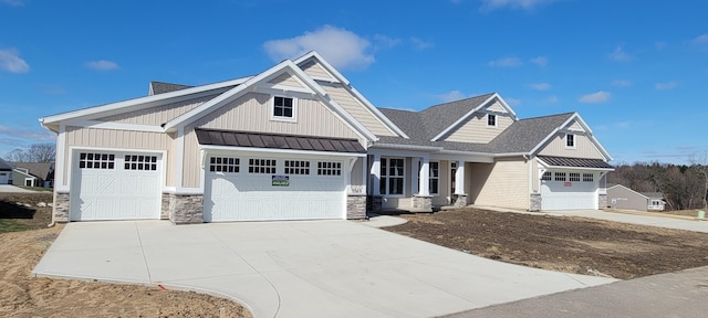 view of front facade featuring stone siding, an attached garage, driveway, and board and batten siding