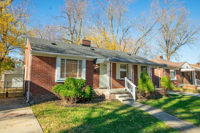 view of front of house featuring a garage, a front lawn, and an outdoor structure