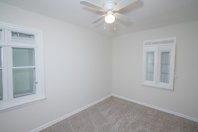 carpeted spare room with ceiling fan