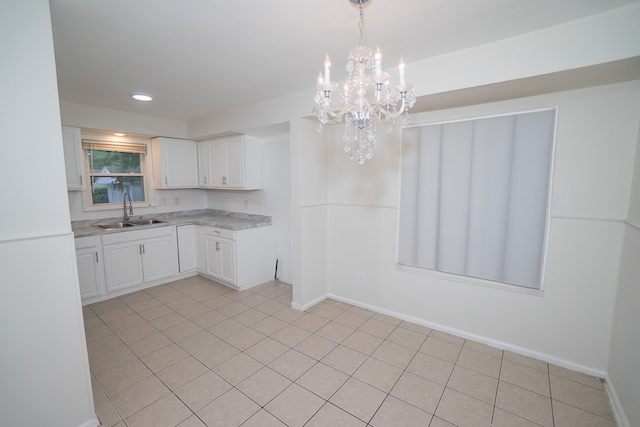 kitchen with sink, light tile patterned floors, white cabinets, a chandelier, and hanging light fixtures