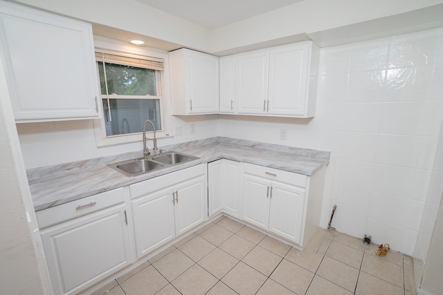 kitchen with sink, white cabinets, and light tile patterned flooring