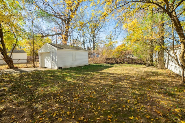 view of yard featuring a garage and an outbuilding