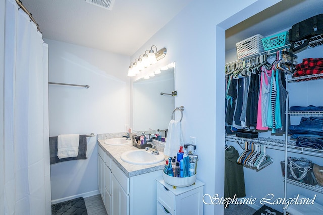 5337 Division Ave N, Comstock Park, MI 49321 - full bathroom with a spacious closet, double vanity, and baseboards