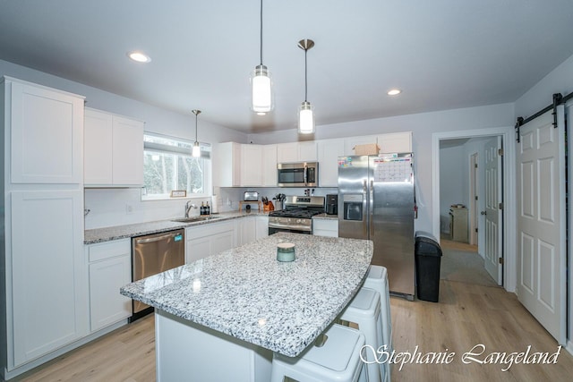 5337 Division Ave N, Comstock Park, MI 49321 - kitchen with appliances with stainless steel finishes, light wood-style floors, white cabinets, and recessed lighting