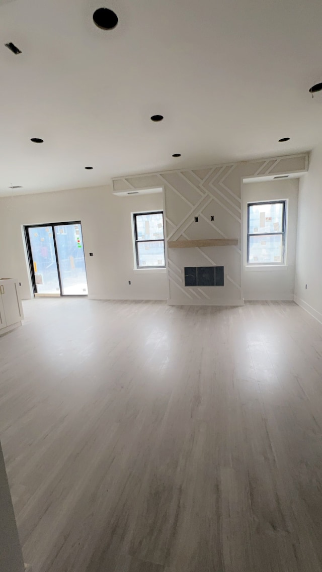 unfurnished living room featuring a wealth of natural light and hardwood / wood-style flooring