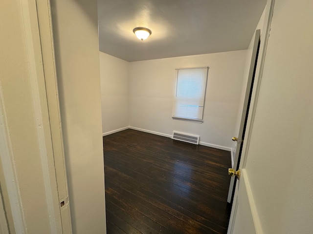 spare room with dark wood-type flooring