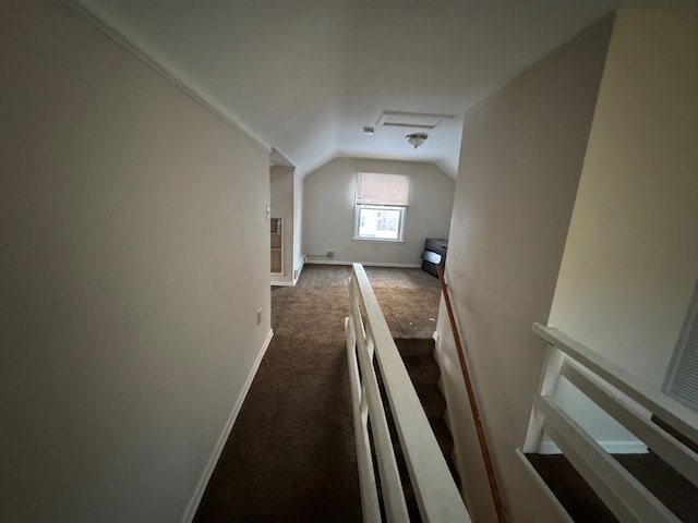 additional living space featuring dark carpet and vaulted ceiling