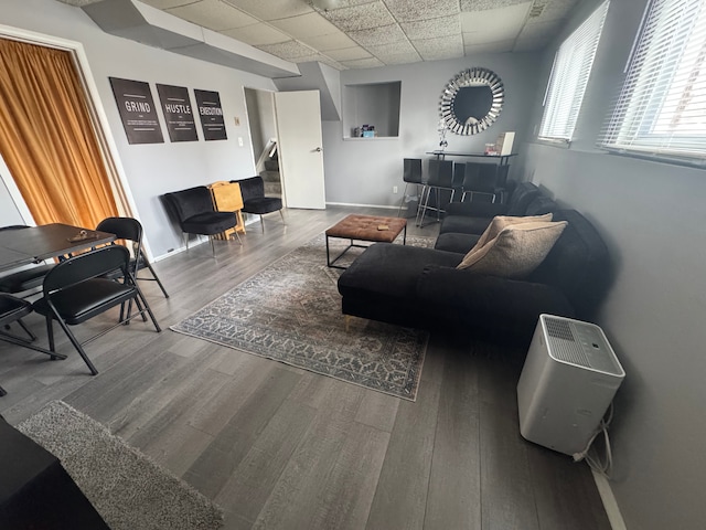 living room with hardwood / wood-style flooring and a paneled ceiling