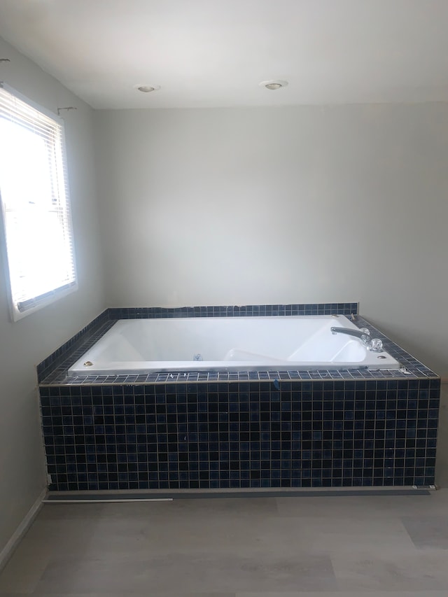 bathroom featuring tile patterned floors and tiled tub