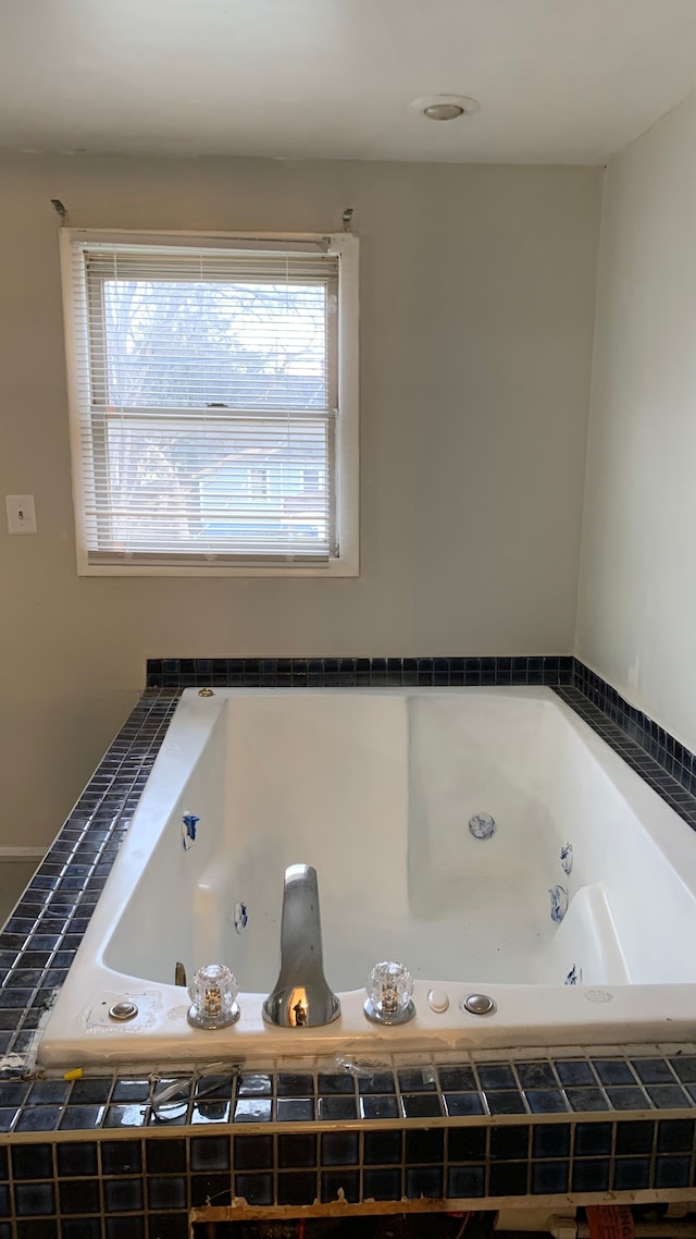 bathroom with a relaxing tiled tub