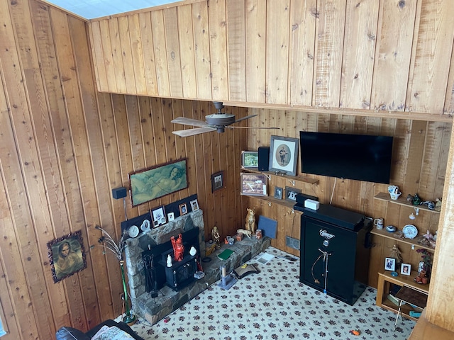 carpeted living room with wooden walls and ceiling fan