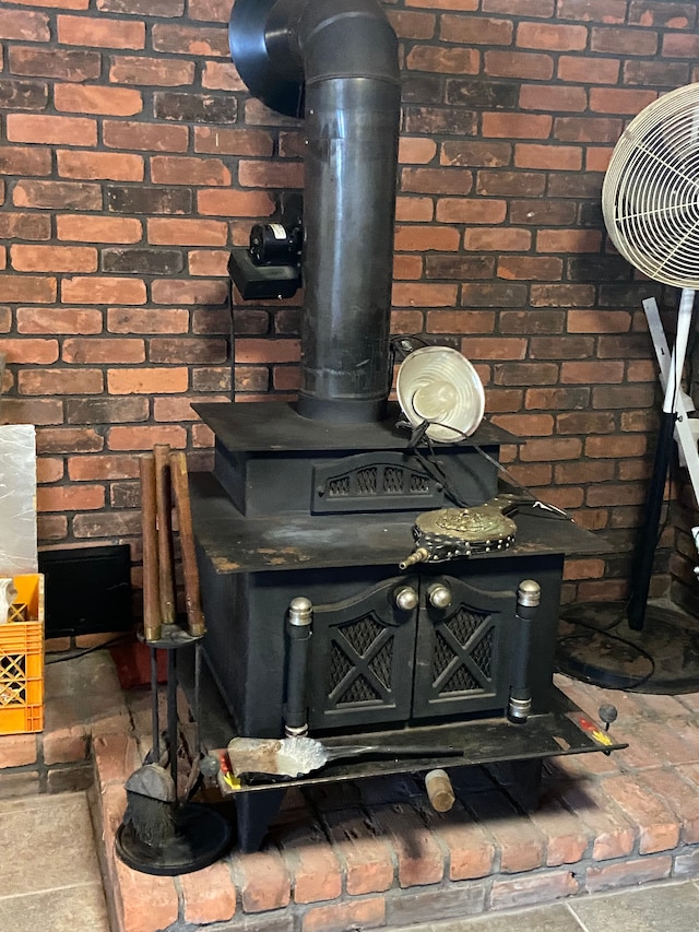 8899 Dwyer Rd, Howell, MI 48855 - detailed view of a wood stove and brick wall