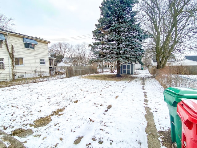 snowy yard featuring a shed