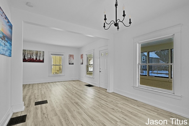 interior space with light wood-type flooring and a notable chandelier