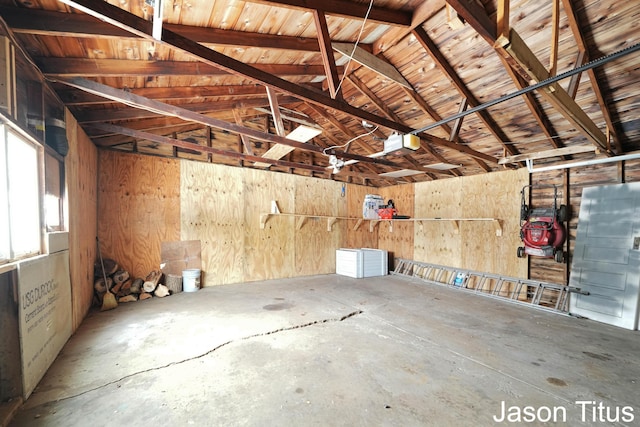 garage with a garage door opener and wood walls