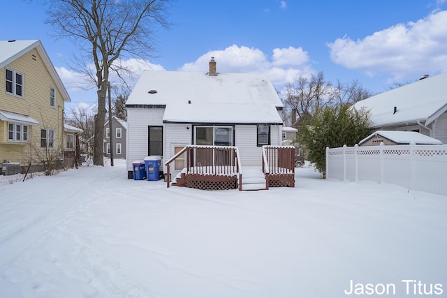 snow covered house featuring a wooden deck and cooling unit