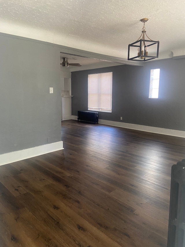 unfurnished room with a chandelier, radiator heating unit, dark hardwood / wood-style floors, and a textured ceiling