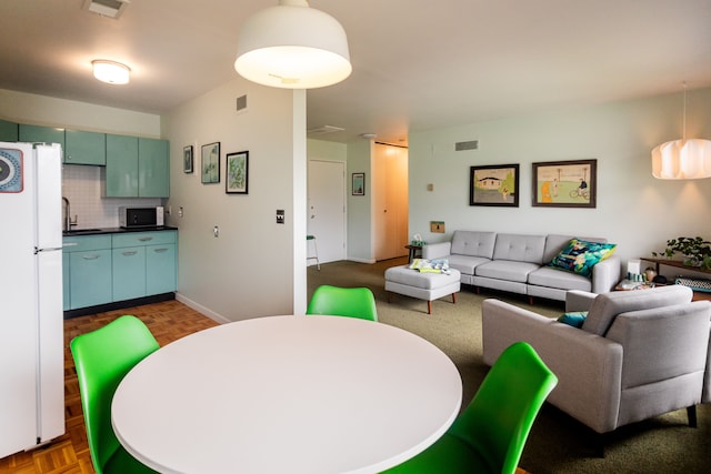 dining area featuring dark parquet flooring and sink