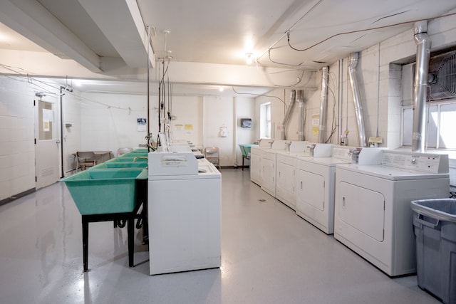 clothes washing area with washer and clothes dryer and sink