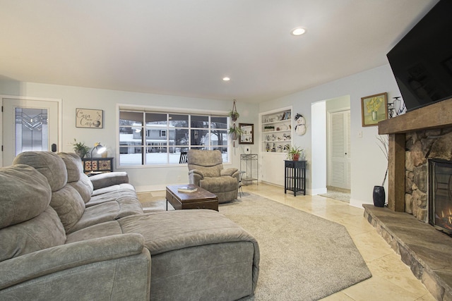 living room featuring built in shelves, light tile patterned flooring, and a stone fireplace