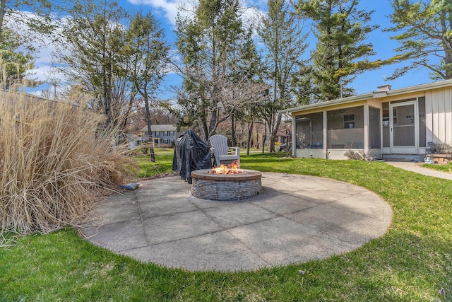 view of patio featuring a sunroom and an outdoor fire pit