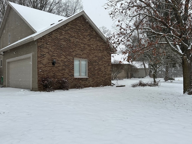 view of snow covered exterior with a garage