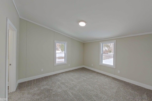 carpeted spare room with lofted ceiling and ornamental molding