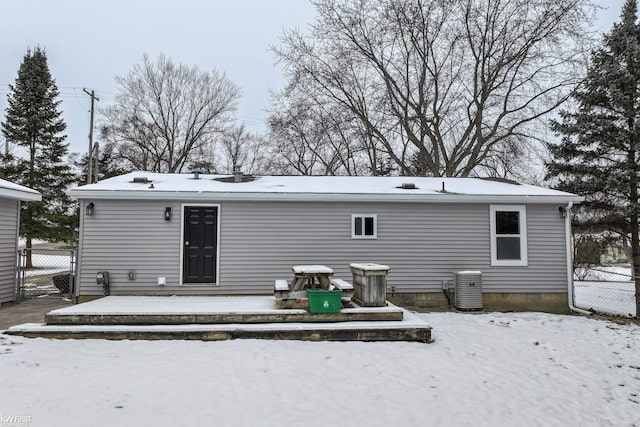 snow covered rear of property with central air condition unit