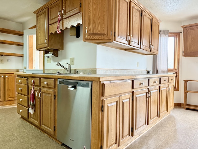 kitchen featuring a textured ceiling, dishwasher, and sink