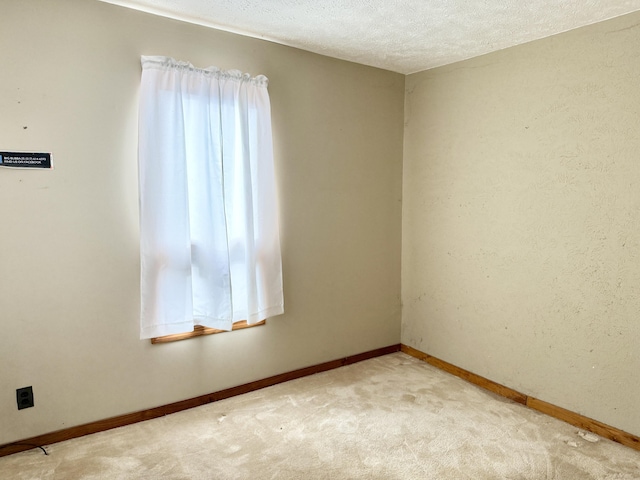 carpeted spare room featuring a textured ceiling