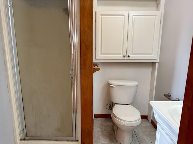 bathroom with tile patterned flooring, toilet, vanity, and walk in shower