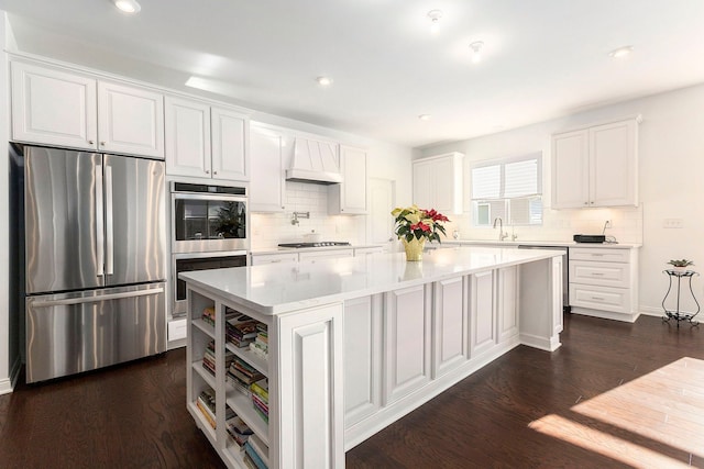 kitchen featuring white cabinets, a kitchen island, custom range hood, and stainless steel refrigerator