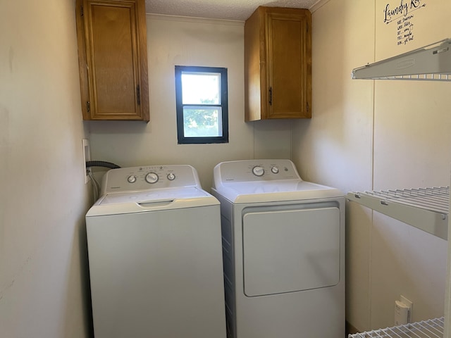 laundry area with cabinets, a textured ceiling, and independent washer and dryer