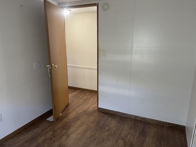 unfurnished room featuring dark wood-type flooring