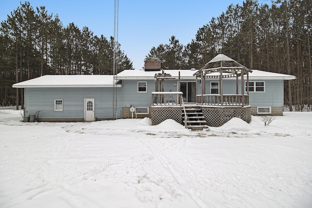 snow covered property featuring a gazebo and a wooden deck