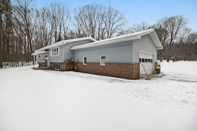 view of snow covered exterior featuring a garage