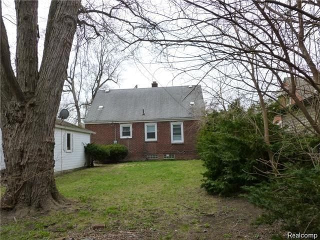 rear view of property with a yard