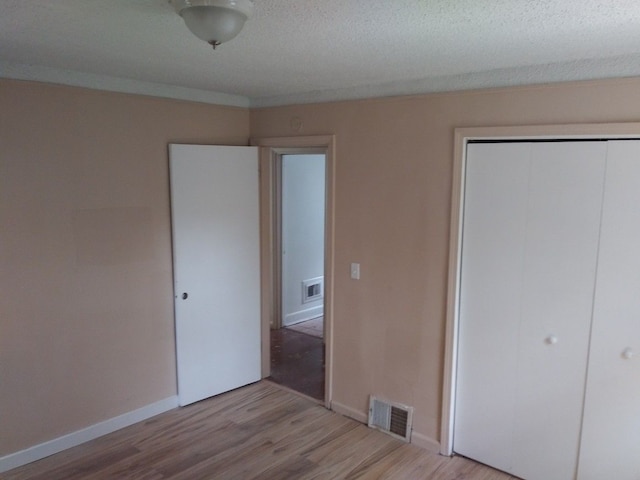 unfurnished bedroom featuring light wood-type flooring and a closet