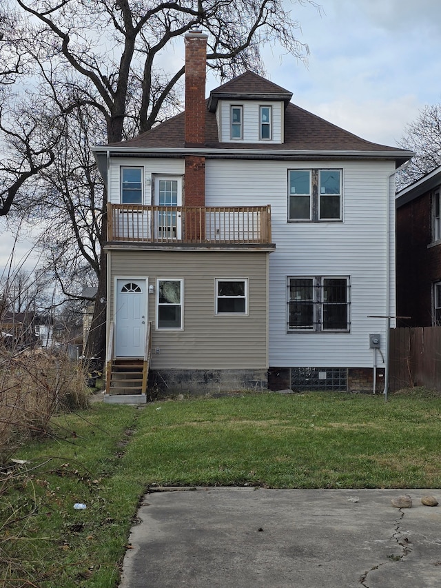 back of property featuring a lawn and a balcony