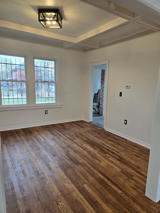 spare room featuring beam ceiling and dark hardwood / wood-style floors