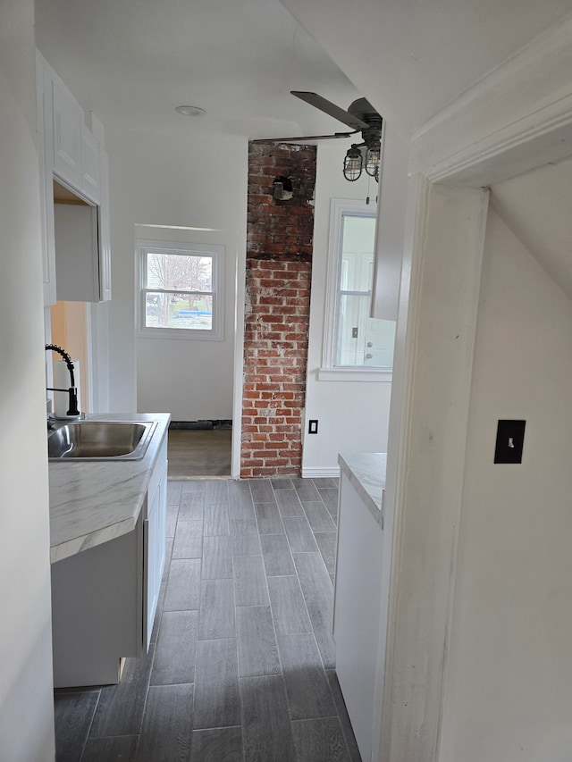 interior space featuring white cabinetry, ceiling fan, and sink