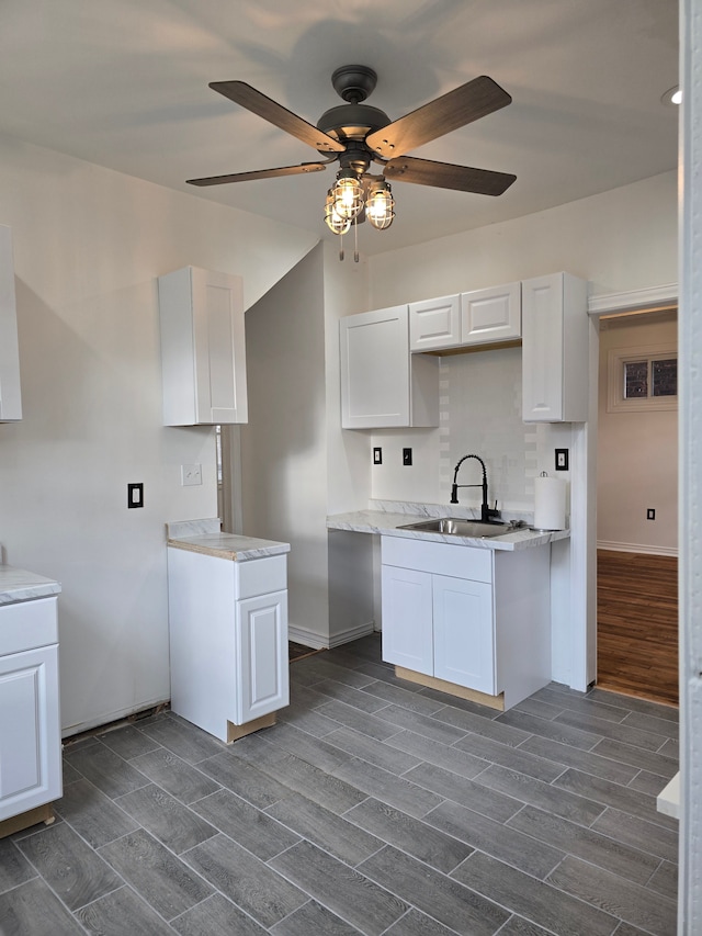 kitchen with ceiling fan, sink, and white cabinets