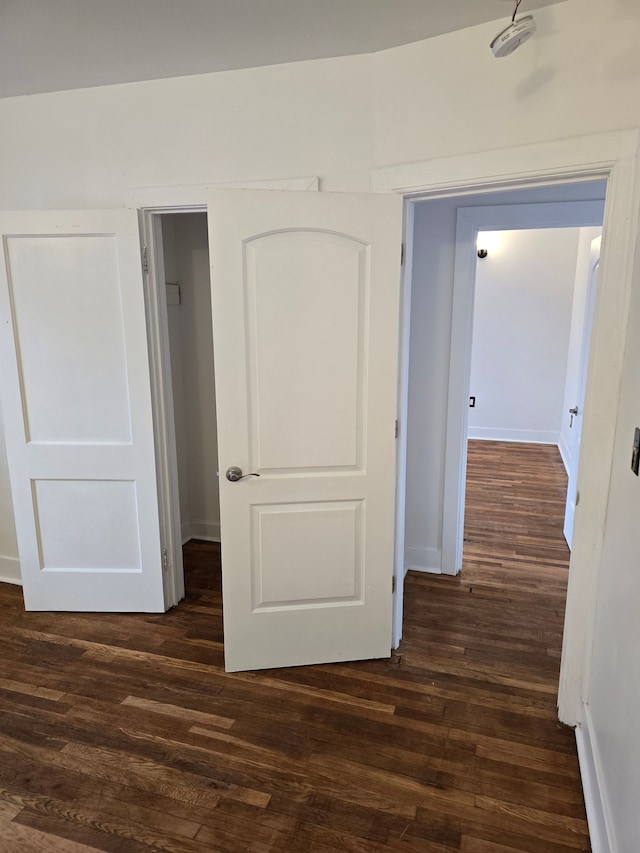 corridor with dark hardwood / wood-style flooring