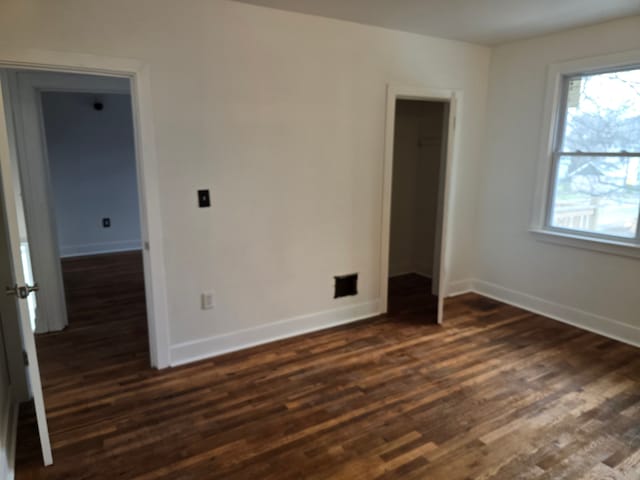 empty room with a healthy amount of sunlight and dark hardwood / wood-style floors