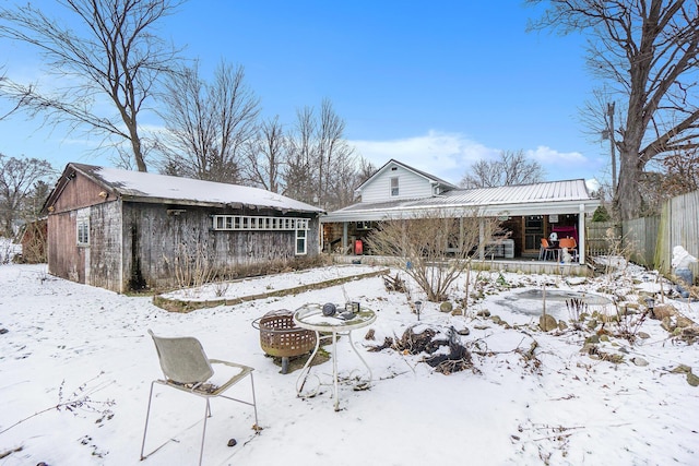 snow covered house featuring a fire pit