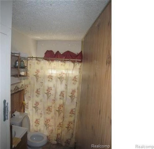 bathroom featuring a textured ceiling and toilet