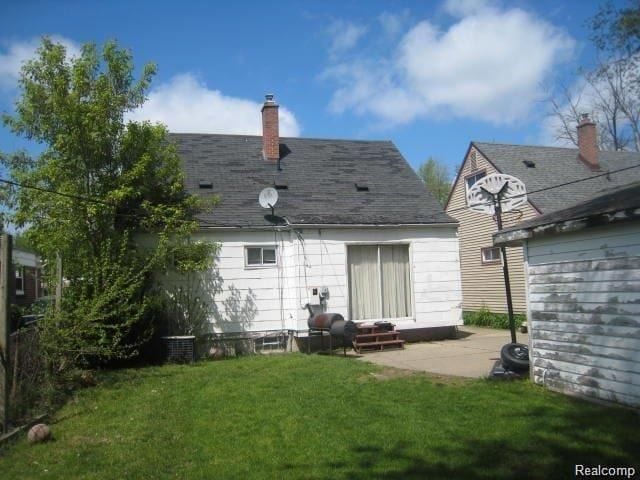 rear view of house featuring a patio area and a yard