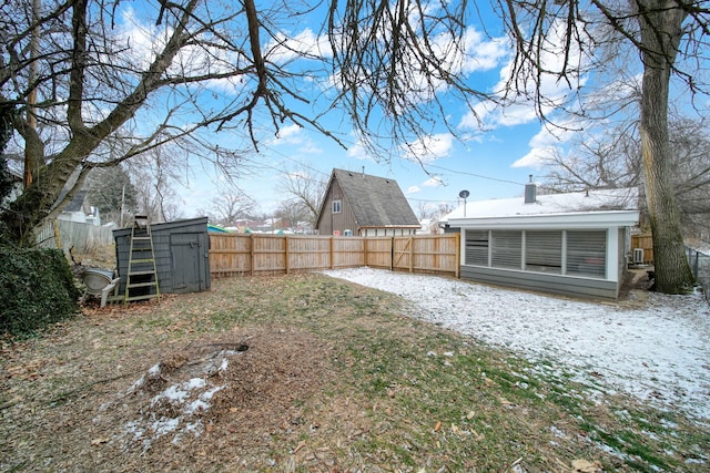 yard layered in snow featuring a storage shed