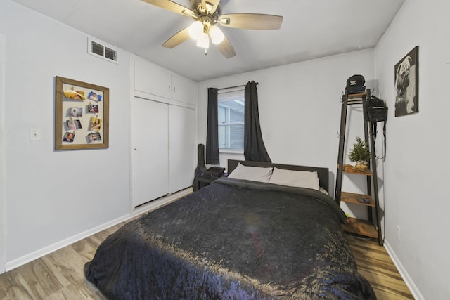 bedroom with ceiling fan, hardwood / wood-style floors, and a closet